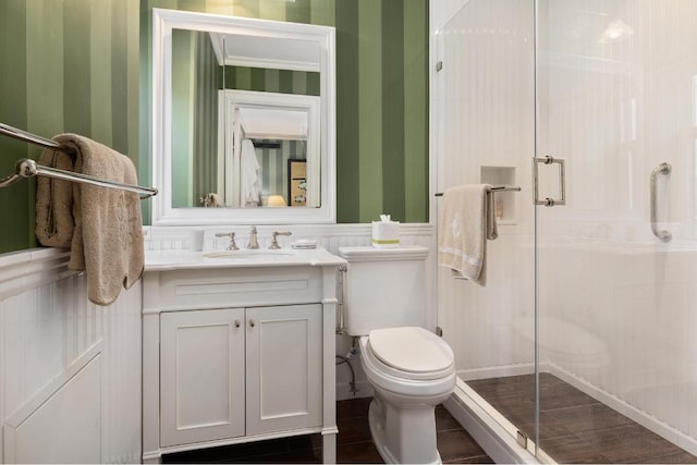 bathroom featuring an enclosed shower, vanity, crown molding, and toilet