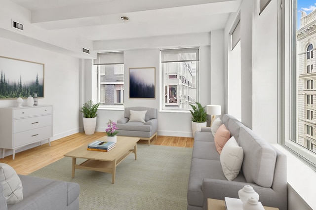 living room with light hardwood / wood-style floors and beam ceiling