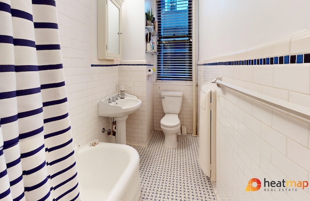 bathroom featuring tile walls, tile patterned floors, plus walk in shower, and toilet