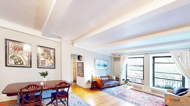 living room featuring ornamental molding, beamed ceiling, and light wood-type flooring