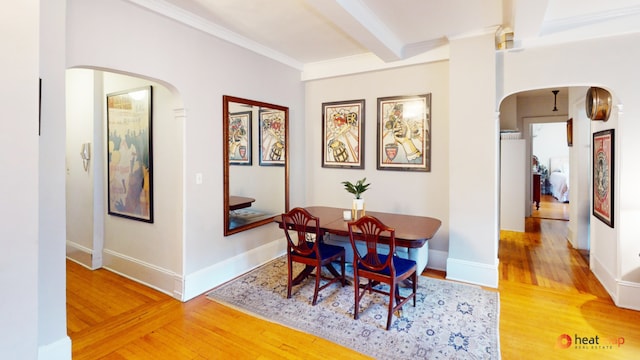 dining area with hardwood / wood-style flooring, beam ceiling, and crown molding