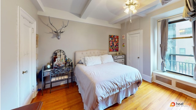 bedroom with ceiling fan, beam ceiling, and light hardwood / wood-style floors