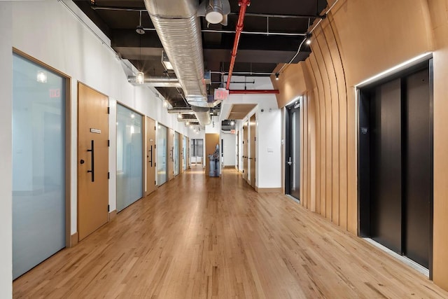 interior space featuring a towering ceiling, light hardwood / wood-style floors, and elevator