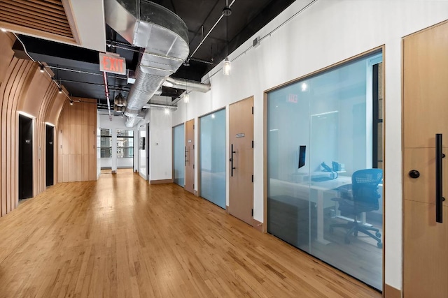 hallway featuring a towering ceiling and hardwood / wood-style floors