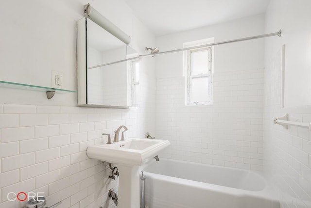 bathroom with tile walls and tiled shower / bath