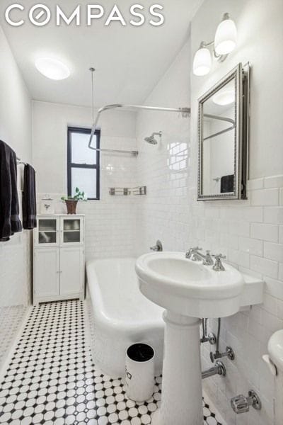 bathroom with tile walls, independent shower and bath, and toilet