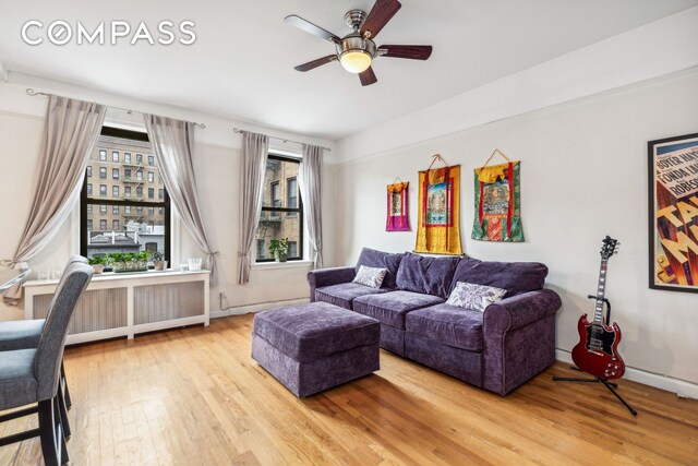 living room featuring radiator, hardwood / wood-style flooring, and ceiling fan