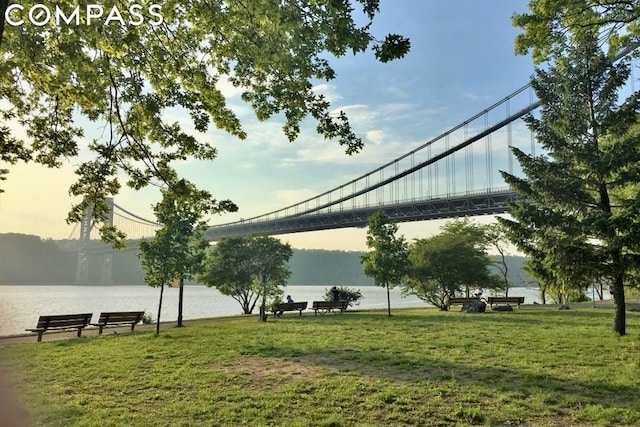 surrounding community featuring a water view and a lawn