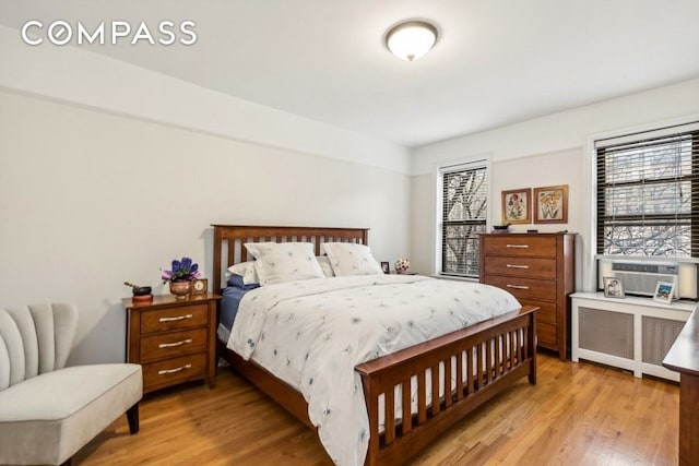 bedroom with light wood-style floors and radiator