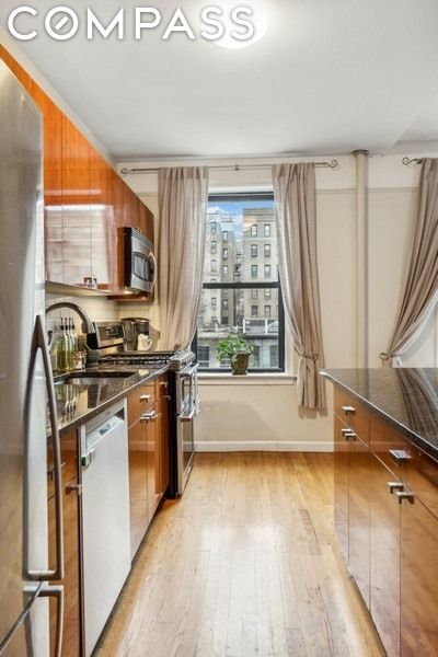 kitchen with appliances with stainless steel finishes and light hardwood / wood-style flooring