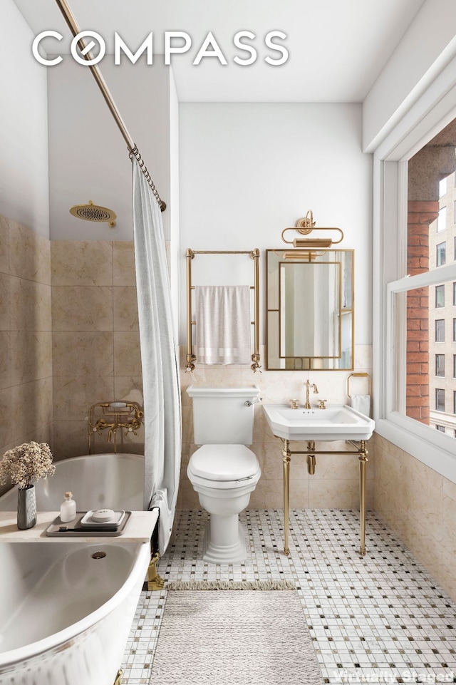 full bathroom featuring tile walls, toilet, tile patterned floors, and a sink