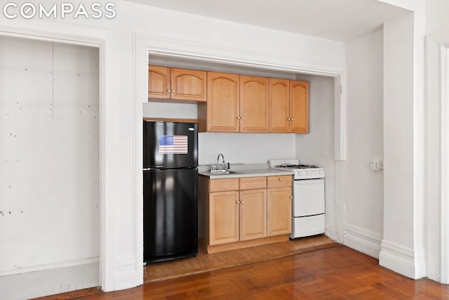 kitchen with light brown cabinetry, sink, white gas range oven, black fridge, and dark hardwood / wood-style flooring