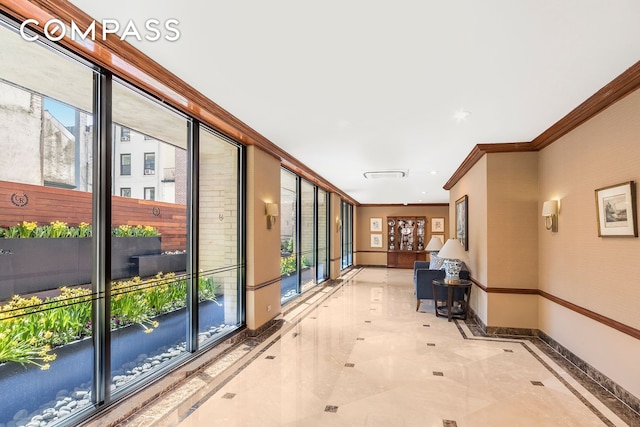 hallway with ornamental molding, marble finish floor, a healthy amount of sunlight, and baseboards