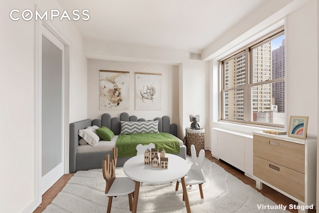 bedroom featuring visible vents and wood finished floors