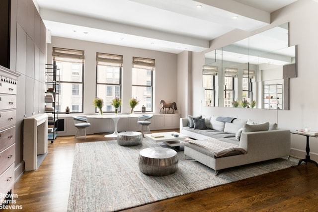 living room featuring wood-type flooring and beamed ceiling