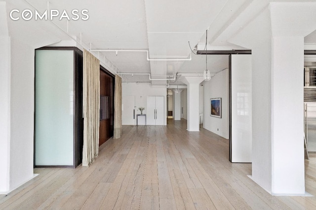 interior space with a barn door and light wood-type flooring