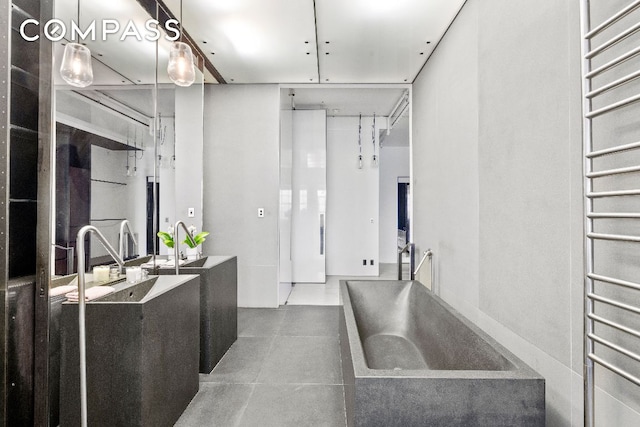 bathroom featuring tile patterned flooring, sink, and radiator