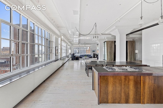 kitchen featuring stainless steel gas stovetop, pendant lighting, and light hardwood / wood-style flooring