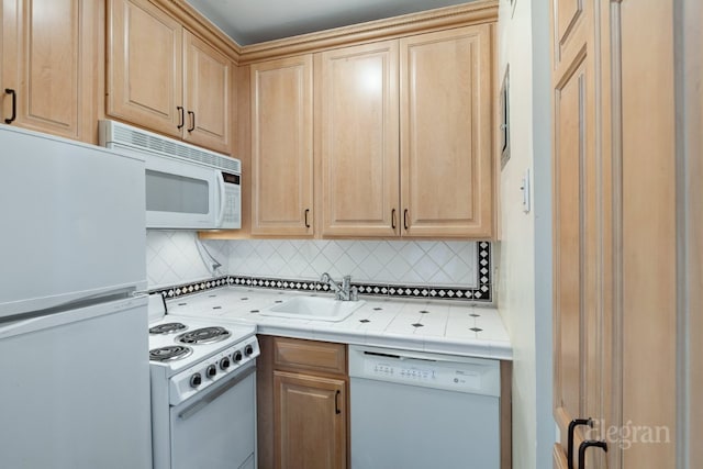 kitchen featuring sink, light brown cabinetry, white appliances, and decorative backsplash