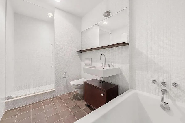 bathroom with a shower, toilet, tile patterned flooring, a bathtub, and a sink