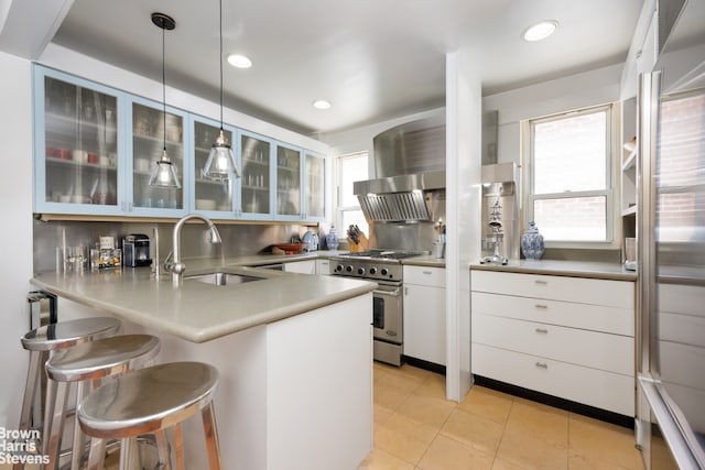 kitchen featuring sink, white cabinetry, kitchen peninsula, pendant lighting, and stainless steel appliances