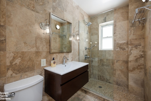 bathroom featuring vanity, tiled shower, tile walls, and toilet