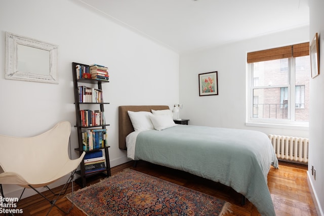 bedroom featuring hardwood / wood-style flooring and radiator