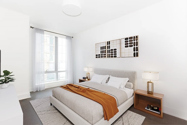 bedroom with finished concrete flooring and baseboards