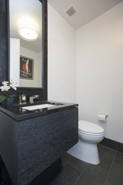 bathroom featuring vanity, tile patterned flooring, and toilet