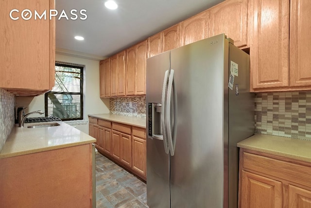 kitchen featuring sink, tasteful backsplash, and stainless steel fridge with ice dispenser