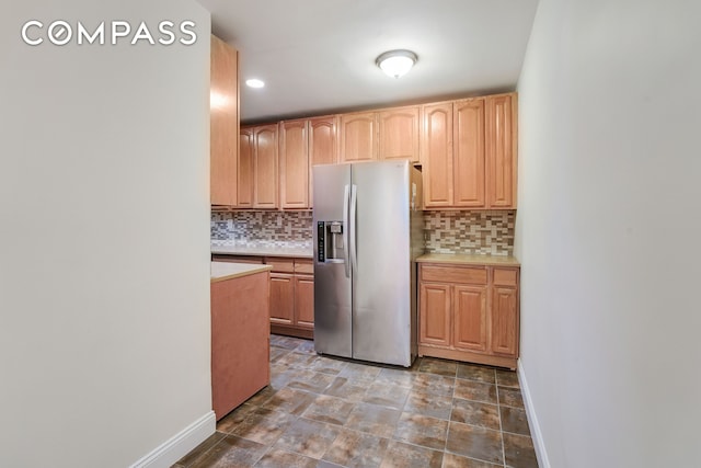 3840 Greystone Ave Unit 1K, New York City, NY 10463 - kitchen featuring stainless steel fridge with ice dispenser, light countertops, backsplash, and baseboards