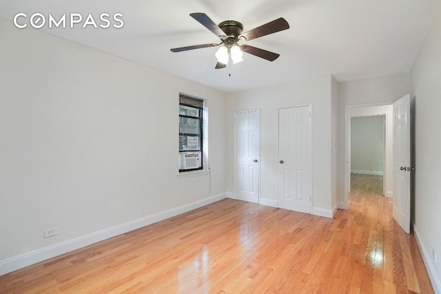 unfurnished bedroom featuring ceiling fan, multiple closets, light hardwood / wood-style floors, and cooling unit