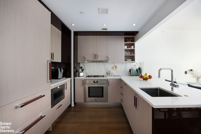 kitchen featuring sink, tasteful backsplash, appliances with stainless steel finishes, dark hardwood / wood-style floors, and kitchen peninsula