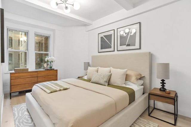 bedroom featuring light wood-type flooring and beam ceiling