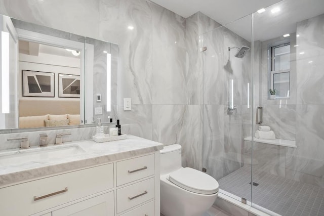 bathroom with tile walls, vanity, toilet, and walk in shower