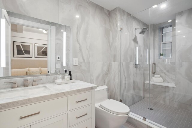 245 W 104th St Unit 4C, New York City, NY 10025 - bathroom with a marble finish shower, tile walls, toilet, and vanity