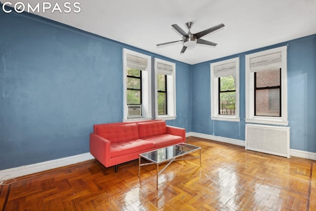 living area with ceiling fan, parquet floors, and radiator heating unit