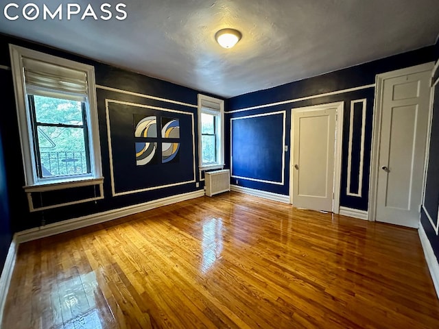 interior space with hardwood / wood-style flooring, plenty of natural light, and radiator