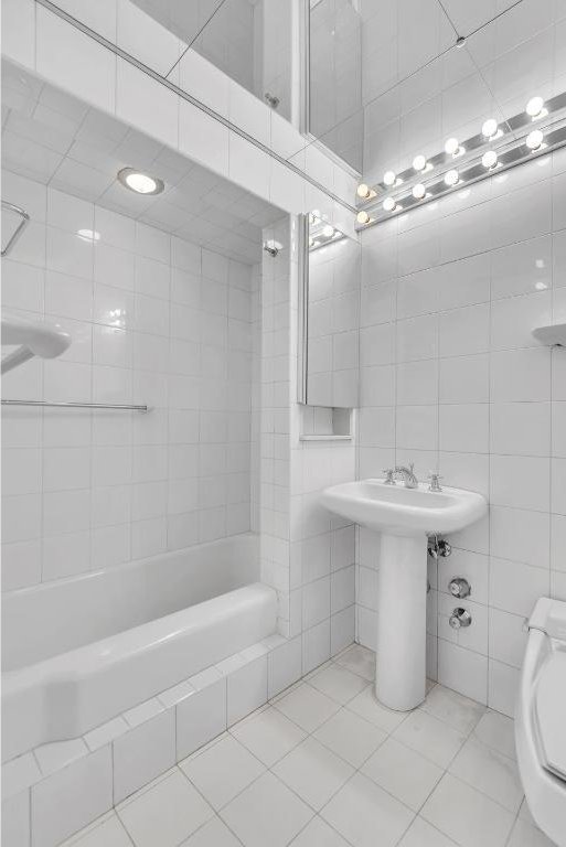 bathroom featuring tile patterned flooring, tile walls, and toilet