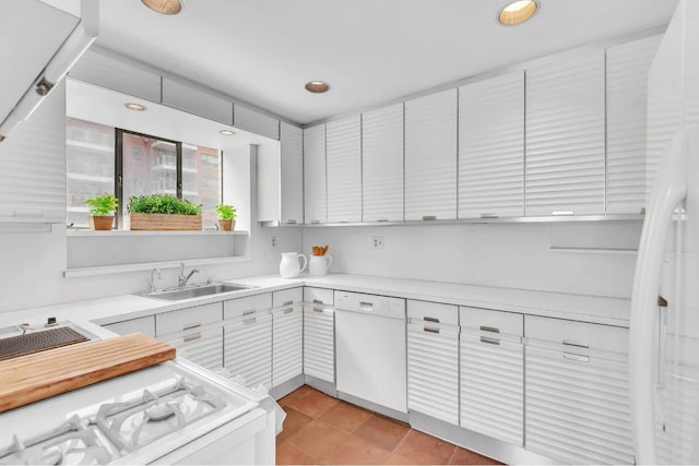 kitchen featuring white cabinetry, sink, white appliances, and light tile patterned floors