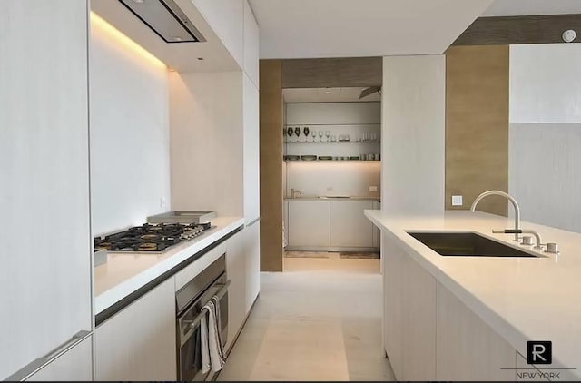 kitchen featuring light countertops, appliances with stainless steel finishes, white cabinetry, a sink, and modern cabinets