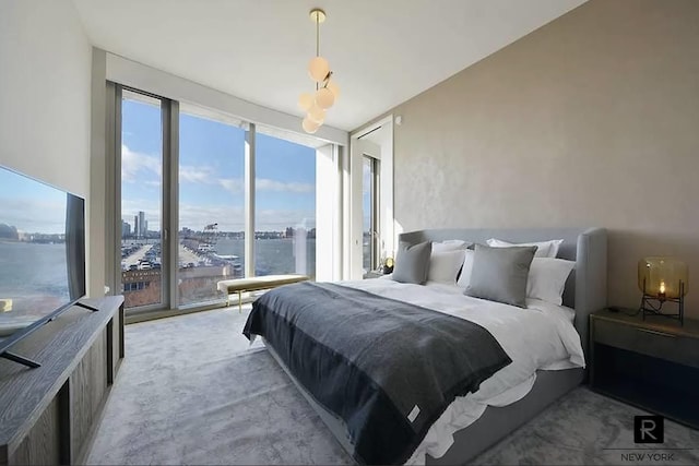 bedroom with a wall of windows and light colored carpet