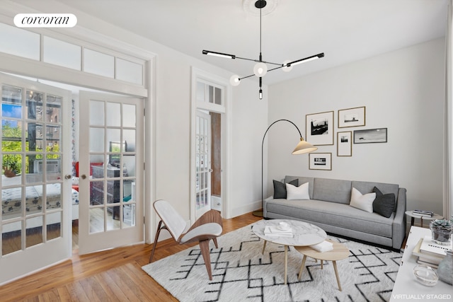 living room featuring wood finished floors, french doors, visible vents, and a chandelier