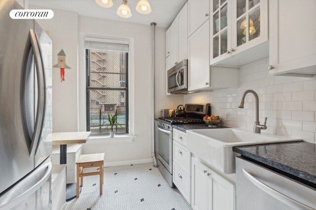 kitchen featuring appliances with stainless steel finishes, backsplash, white cabinetry, and plenty of natural light