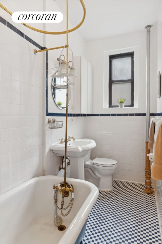 full bath with tile walls, toilet, and a washtub