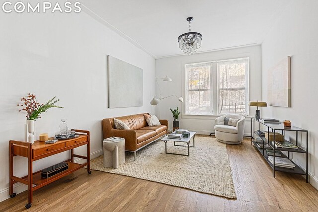 living room with hardwood / wood-style floors and a notable chandelier