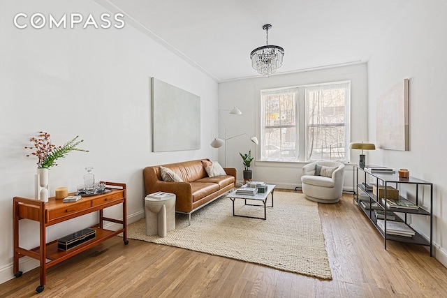 living room with baseboards, an inviting chandelier, and hardwood / wood-style flooring