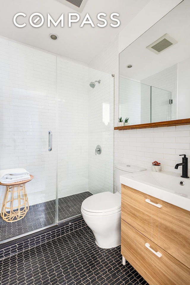 full bath featuring vanity, toilet, tile walls, and a shower stall