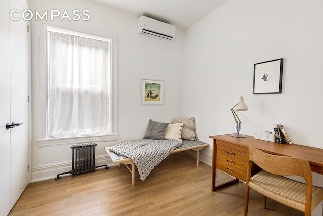 living area featuring light wood-type flooring, radiator, and a wall mounted AC