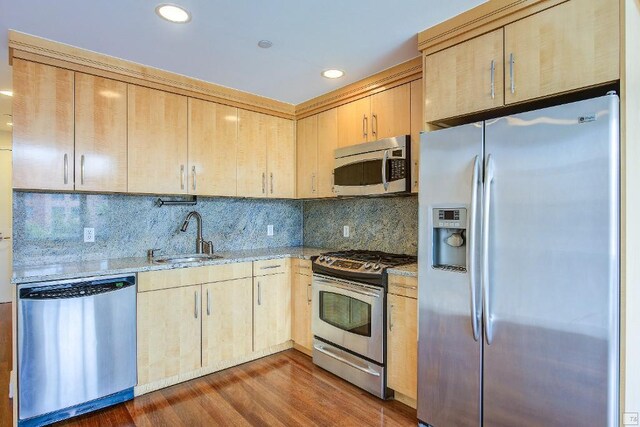 kitchen with dark wood-type flooring, light brown cabinetry, sink, appliances with stainless steel finishes, and backsplash